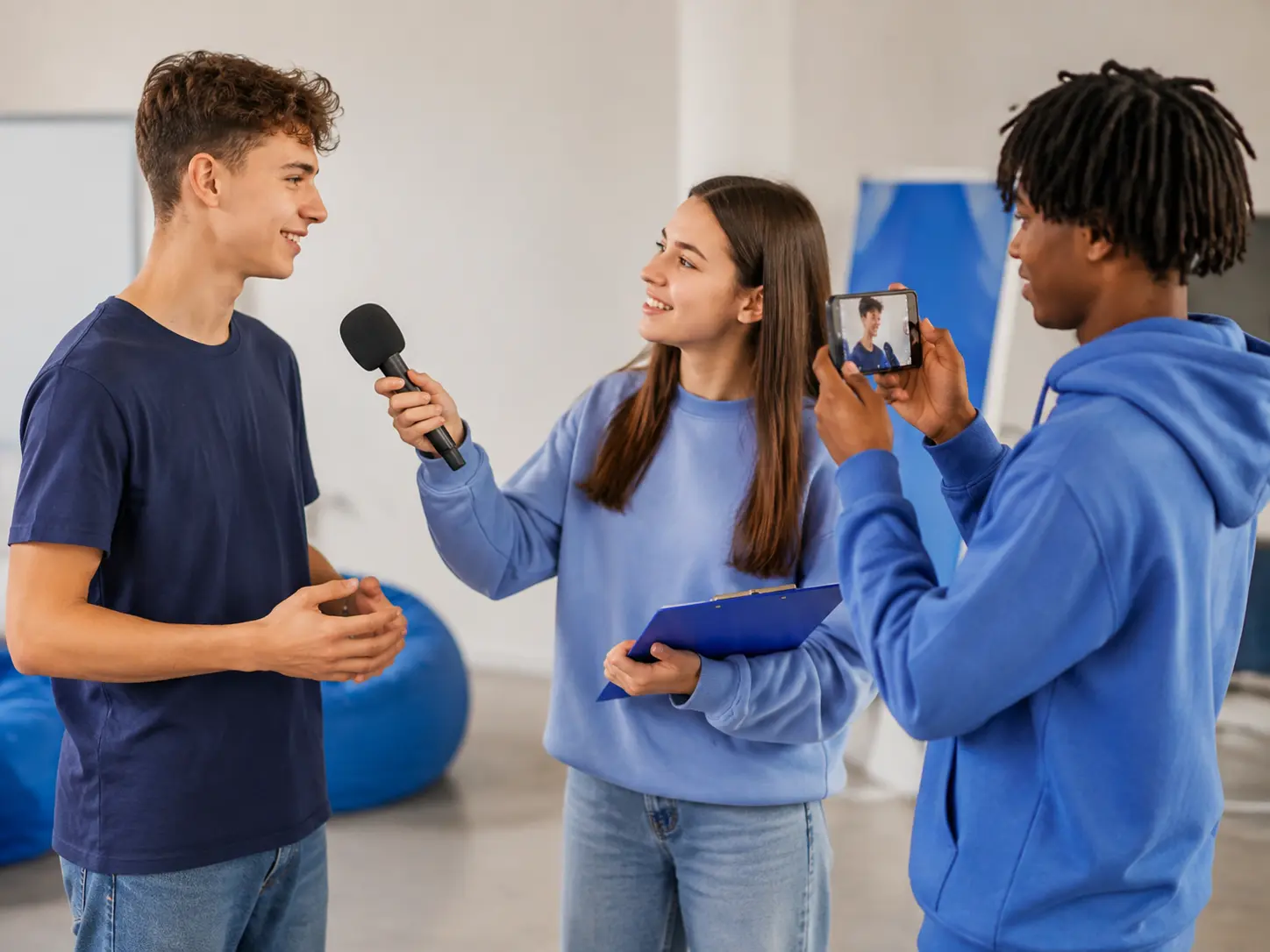 Jugendliche führen mit Mikrofon und Smartphone ein Interview